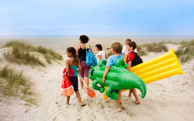 Kinderen lopen op het strand in Zeeland.